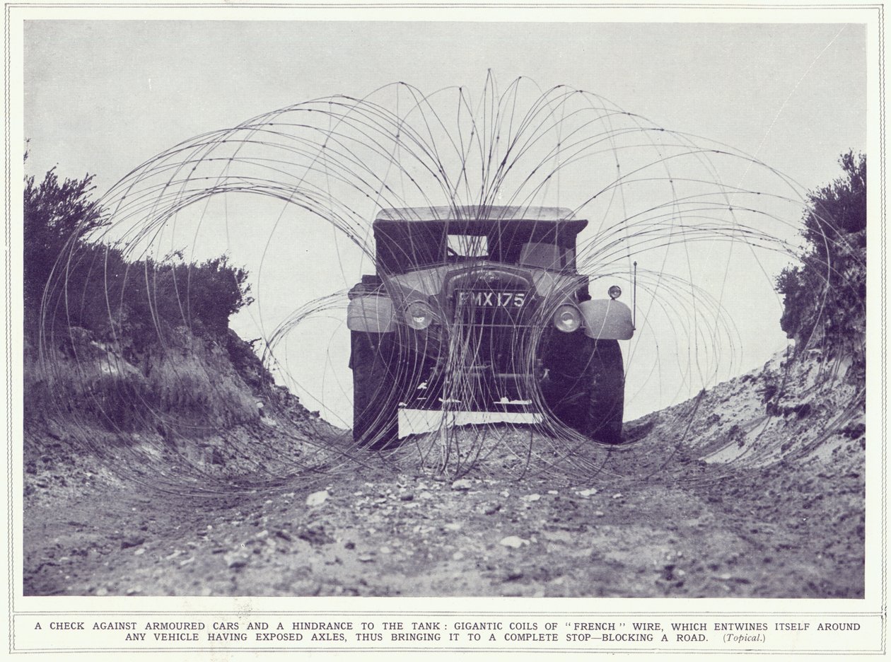 Obrněný vůz je zastaven gigantickými cívkami francouzského drátu, který blokuje silnici, z The Illustrated War News, publikované 22. listopadu 1939 od English Photographer