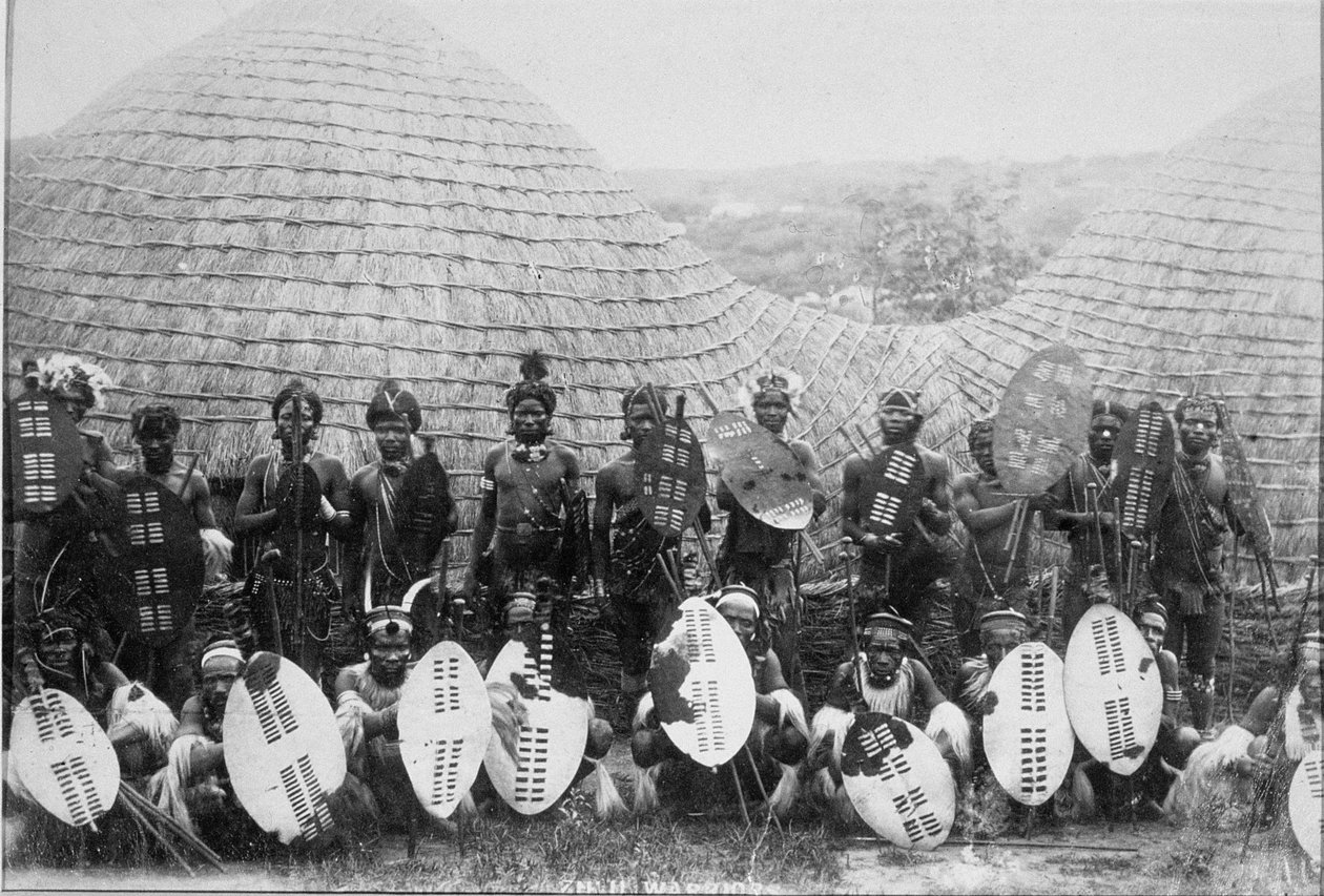 Skupinový portrét zuluských válečníků před chatou, kolem roku 1875 (tisk alba) od English Photographer