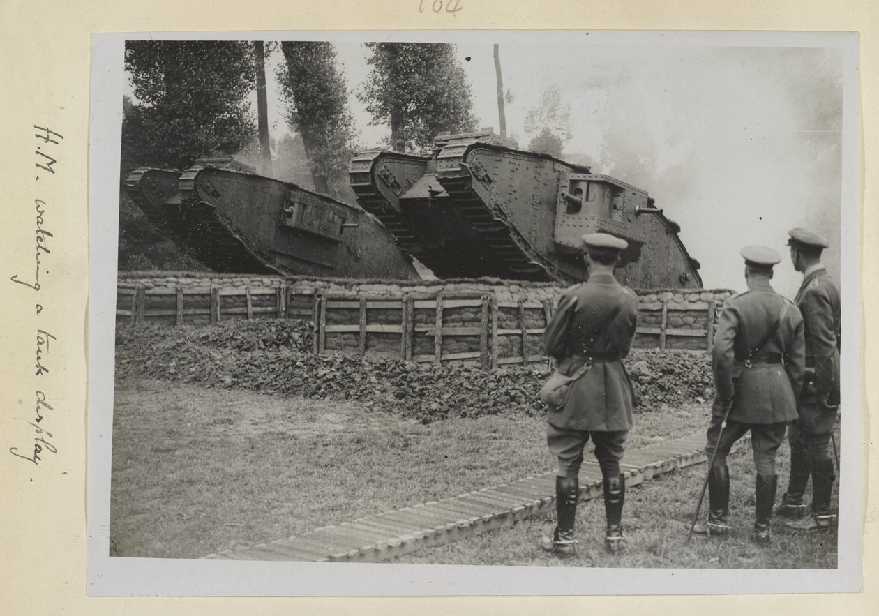 Tři důstojníci, možná jeden král Jiří V., sledovali dva tanky, jak přejíždějí překážku, 1915-18 od English Photographer