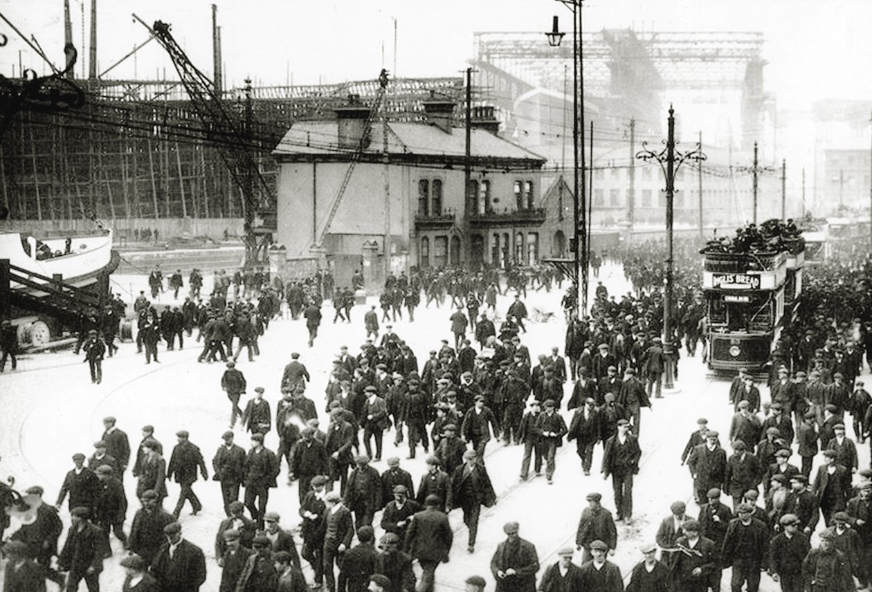 Zahajovací čas v loděnici Harland and Wolff, Belfast, Irsko s rozestavěným Titanikem v pozadí, 1910-11 od English Photographer