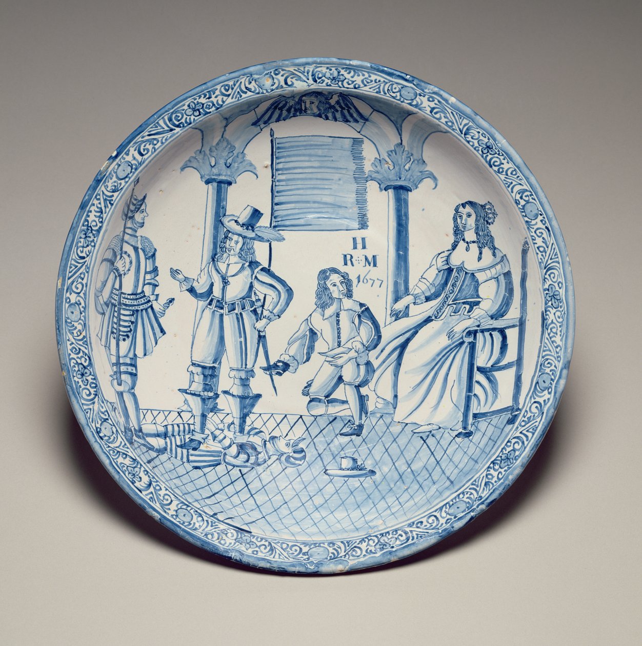 Miska se sedící královnou Kateřinou s botou osazenou klečícím kavalírem, 1677 (cínová glazovaná kamenina) od English School