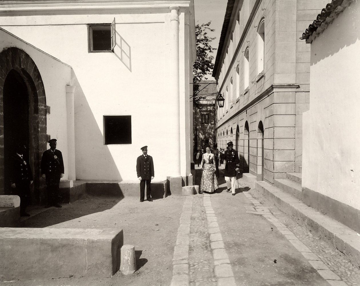 Muži v uniformě doprovázející elegantně oblečenou ženu směrem ke kostelu farmy Lo Zucco, Sicílie, 1900 od Eugenio Interguglielmi