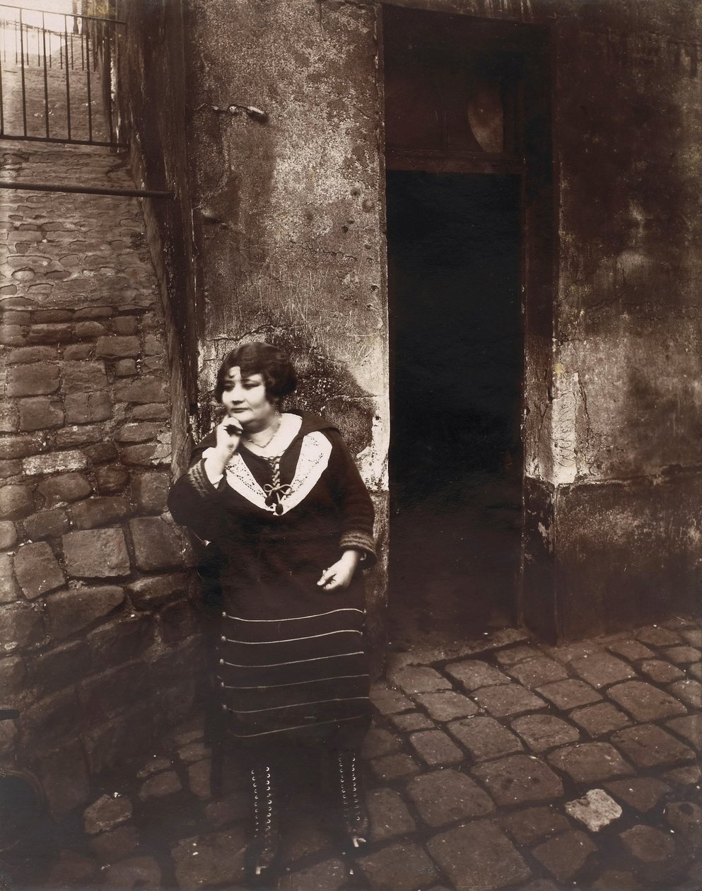 La Villette. Rue Asselin, prostitutka čekající před jejími dveřmi od Eugène Atget