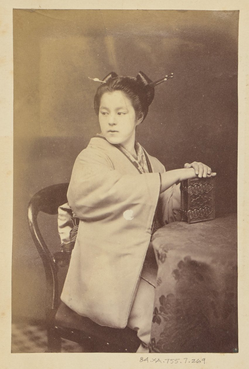 [Sedící Japonka držící u stolu album cartes-de-visite] od Felice Beato