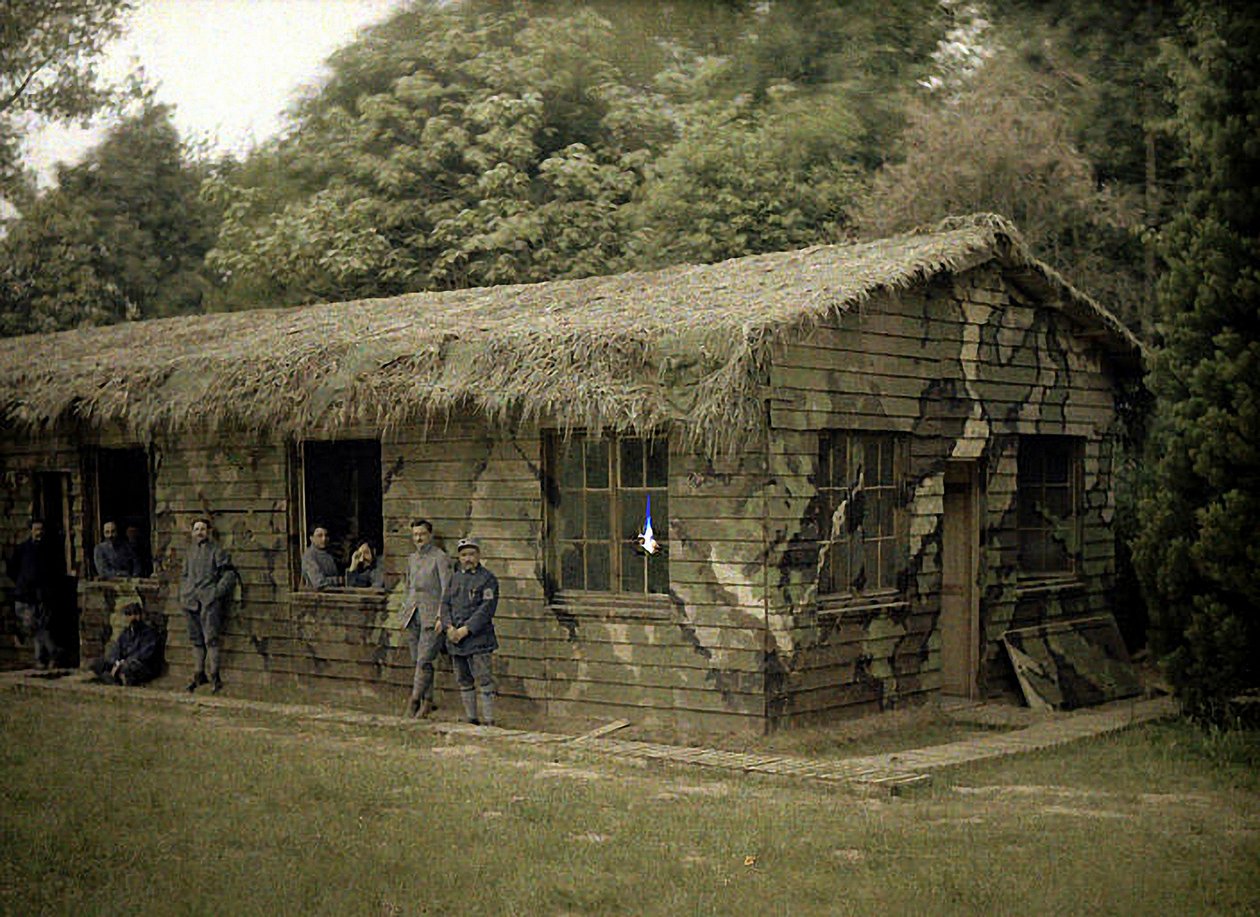 Devět francouzských vojáků v dřevěné budově s vojenskou kamufláží, Soissons, Aisne, Francie, 1917 (autochrom) od Fernand Cuville