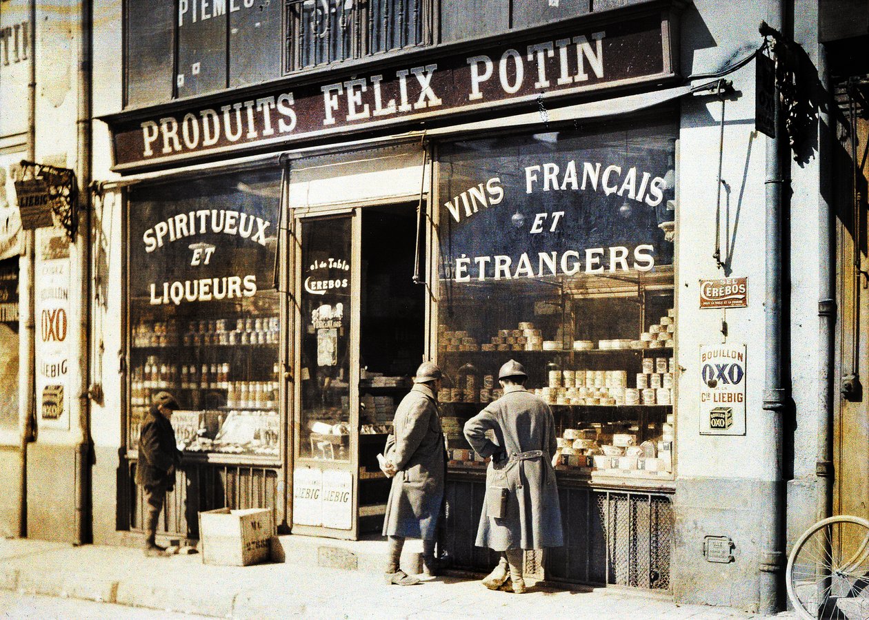 Dva francouzští vojáci a chlapec před obchodem s alkoholem Felix Potin na trhu, Remeš, Marna, Francie, 1917 (autochrom) od Fernand Cuville