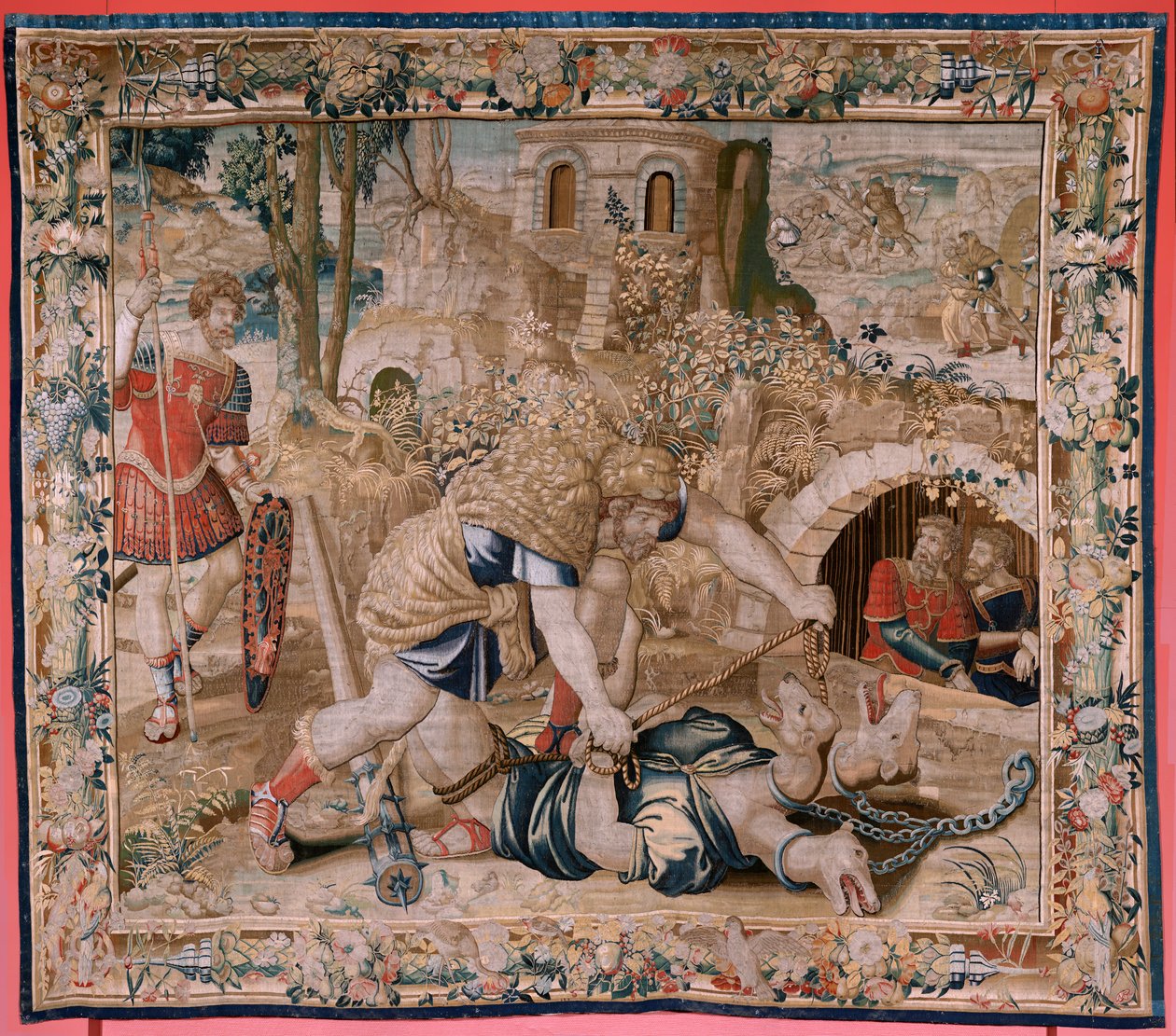 Vlámský gobelín. Seriál The Labors of Hercules. Herkules zajme Cerbera (Hércules captura a Cancerbero). Šestá tapisérie v dochované sérii. Model neznámý. Výroba Willem Dermoyen, Brusel. Ca1528. Tkanina Hedvábí a vlna. Rozměr 345 x 390 cm. Locati od Flemish School