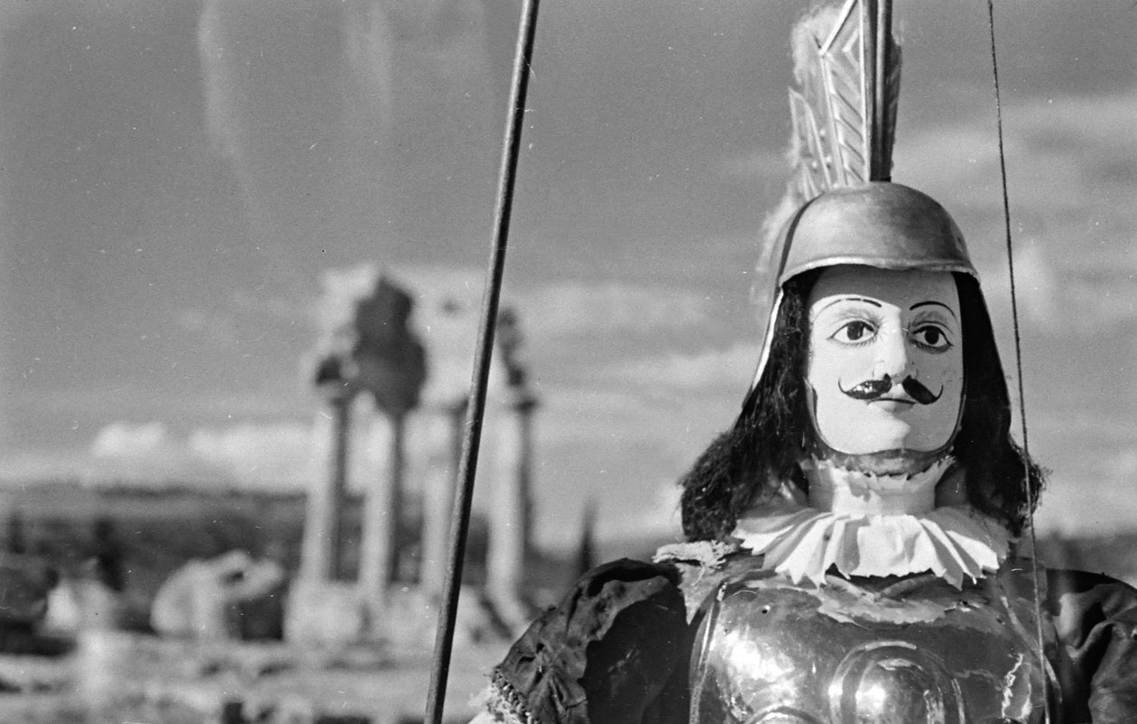 Sicilská loutka. V pozadí chrám Castora a Polluxe neboli Kastora a Polluxe v Údolí chrámů v Agrigentu. od Fosco Maraini