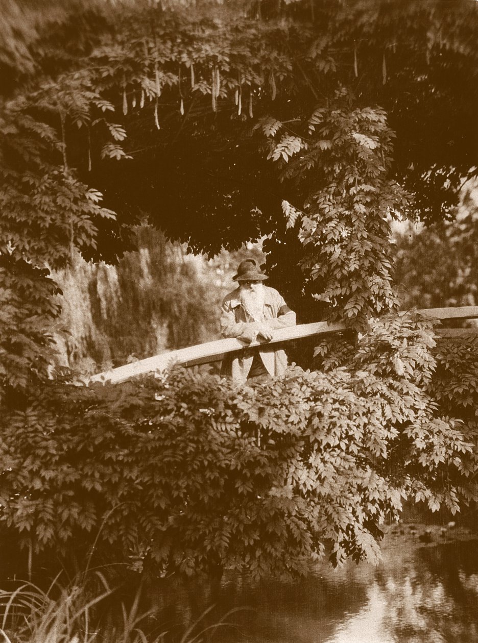 Claude Monet na japonském mostě ve své zahradě v Giverny, kolem roku 1920 od French Photographer
