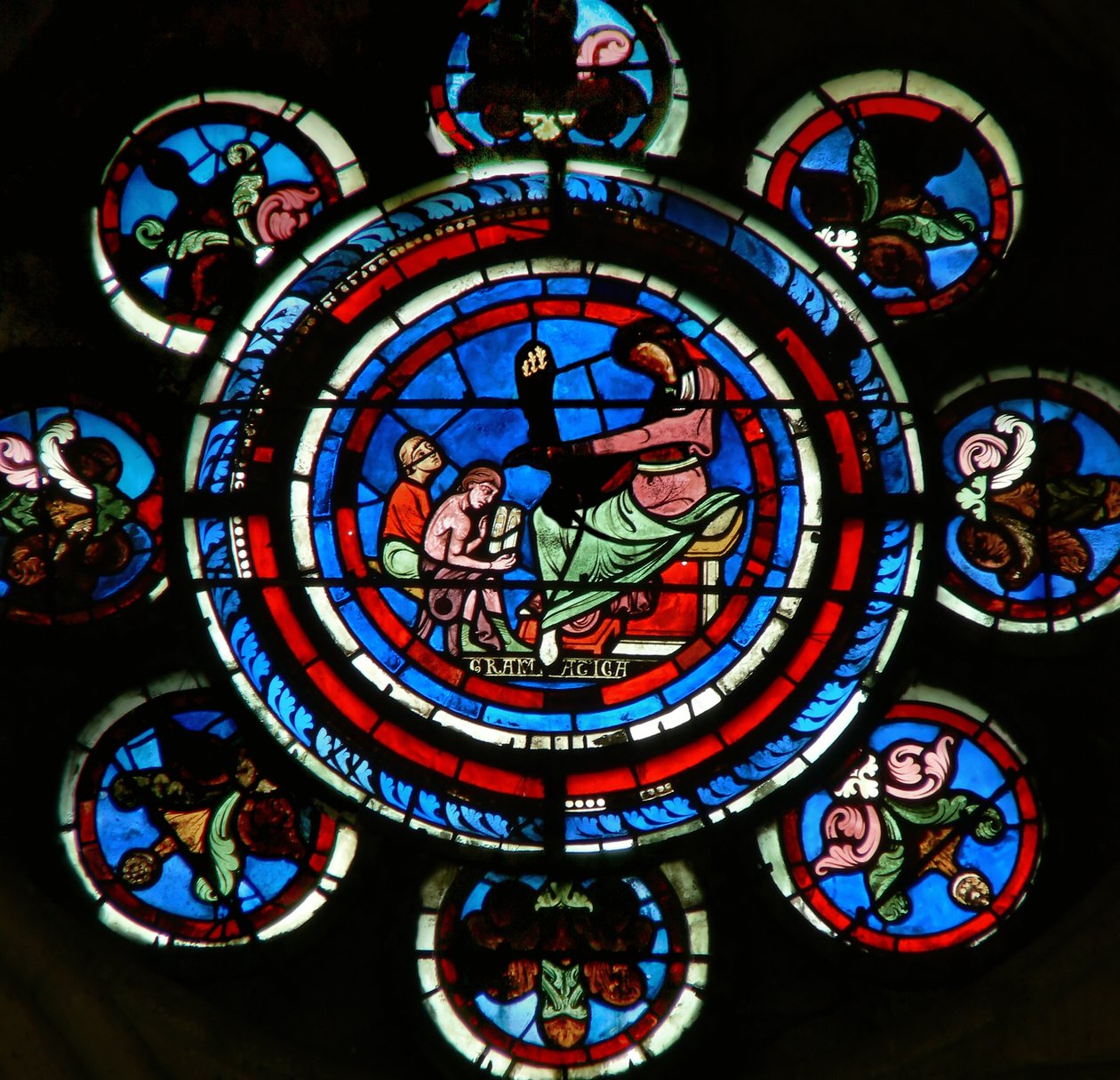 Detail ze severního rozetového okna zobrazující gramatiku ze svobodných umění od French School