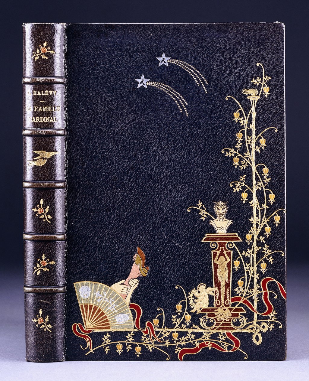 Horní obálka knihy dvě padající hvězdy, pochodeň, listy, faun na podstavci, putto a noha za vějířem, 1893 od French School