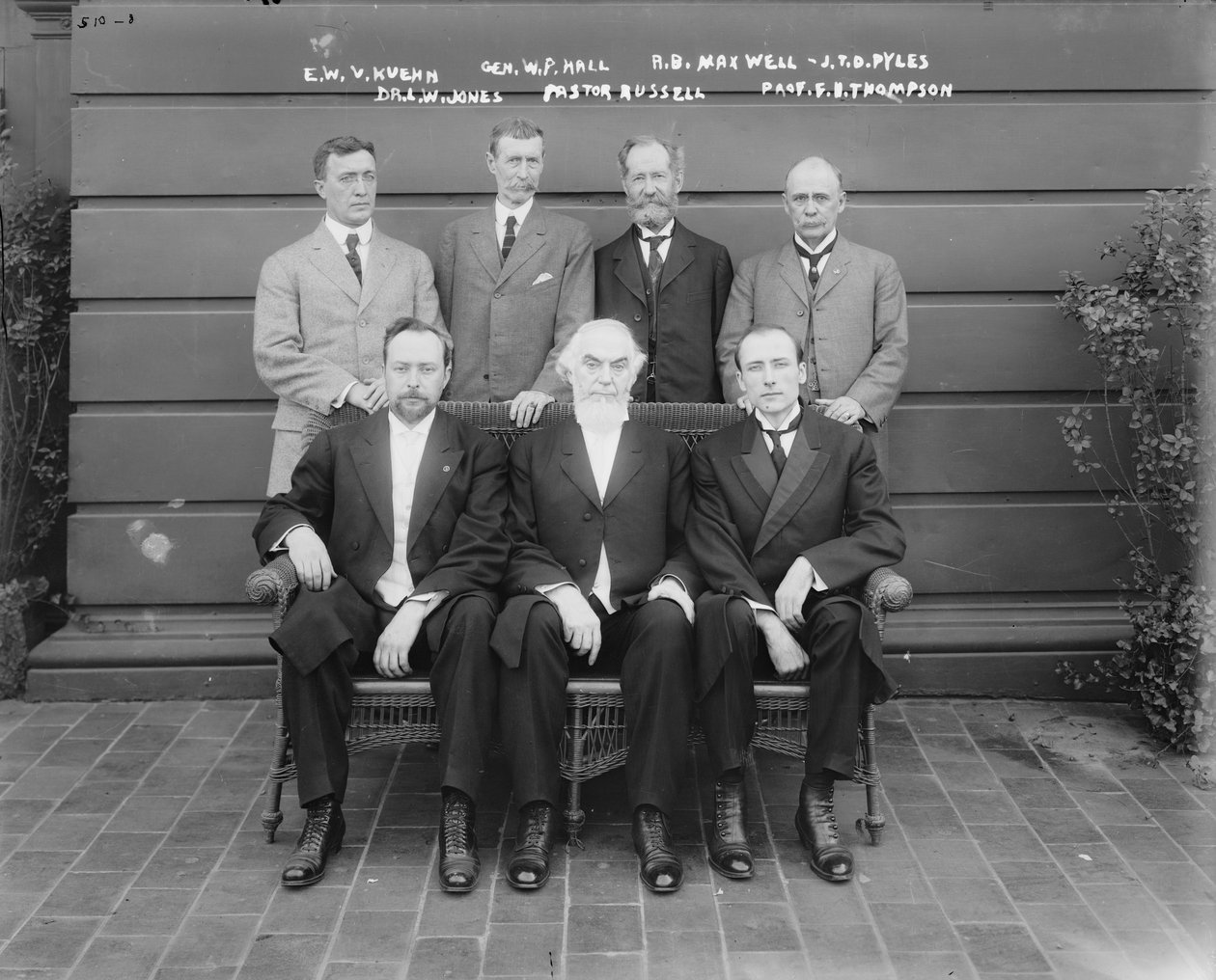 Charles Taze Russell (uprostřed) s Ernestem Wilsonem V. Kuehnem, generálem Williamem P. Hallem, Robertem B. Maxwellem, J.T.D. Pylesem, Dr. Leslie W. Jonesem, profesorem F. B. Thompsonem, 1911 od George Grantham Bain