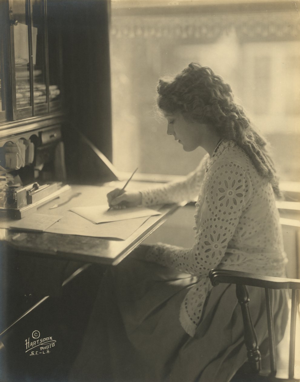 Mary Pickford píše u stolu, kolem roku 1918 (černobílá fotografie) od Bartolome Esteban and studio Murillo
