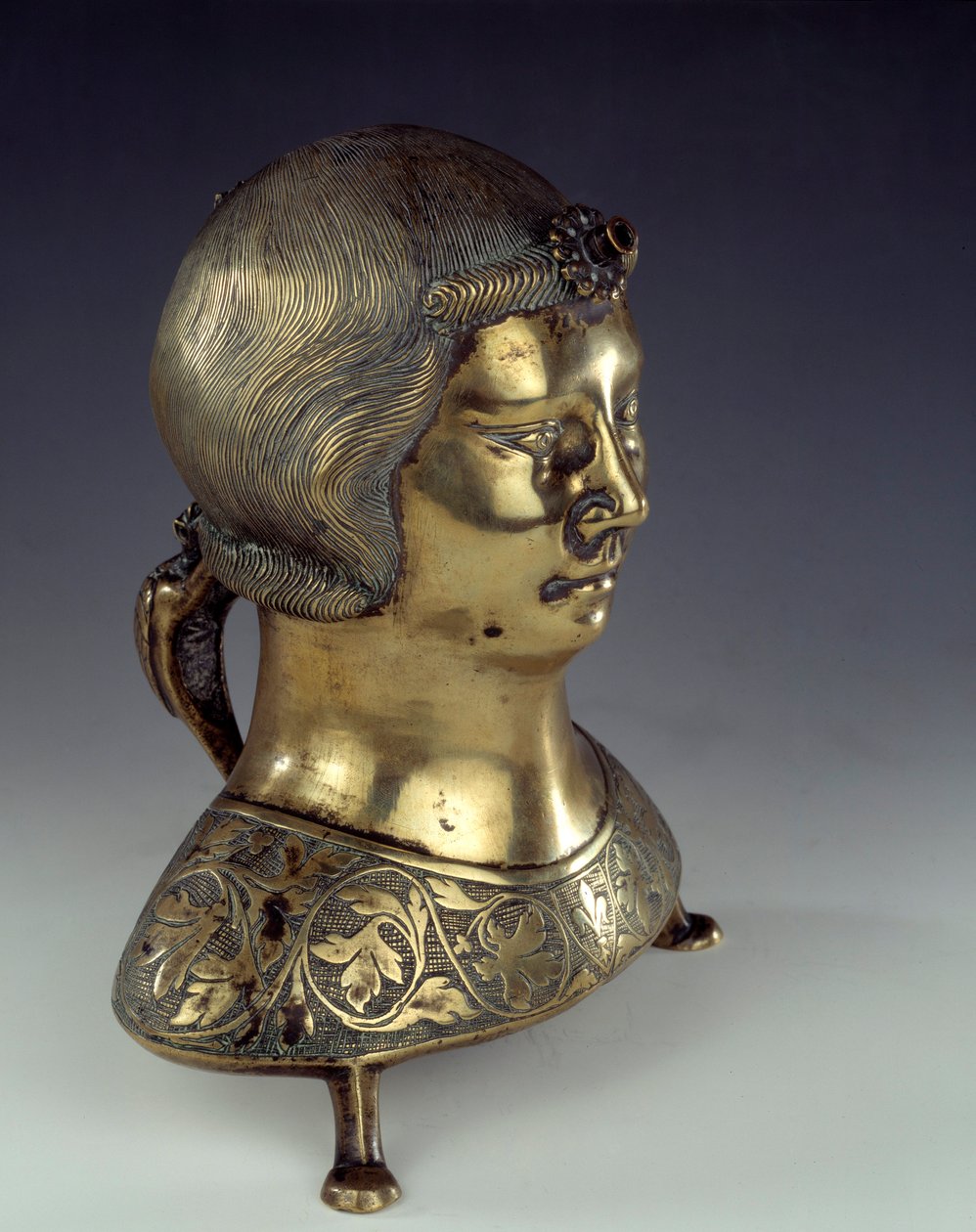 Aquamanile (umyvadlo na mytí rukou kněze při mši) ve zlatém bronzu ve tvaru poprsí mladého muže. 1300-1325. Z Hildesheimu. Slunce 0,23x0,19 m Paříž, národní muzeum středověku, Thermes de Cluny od German School