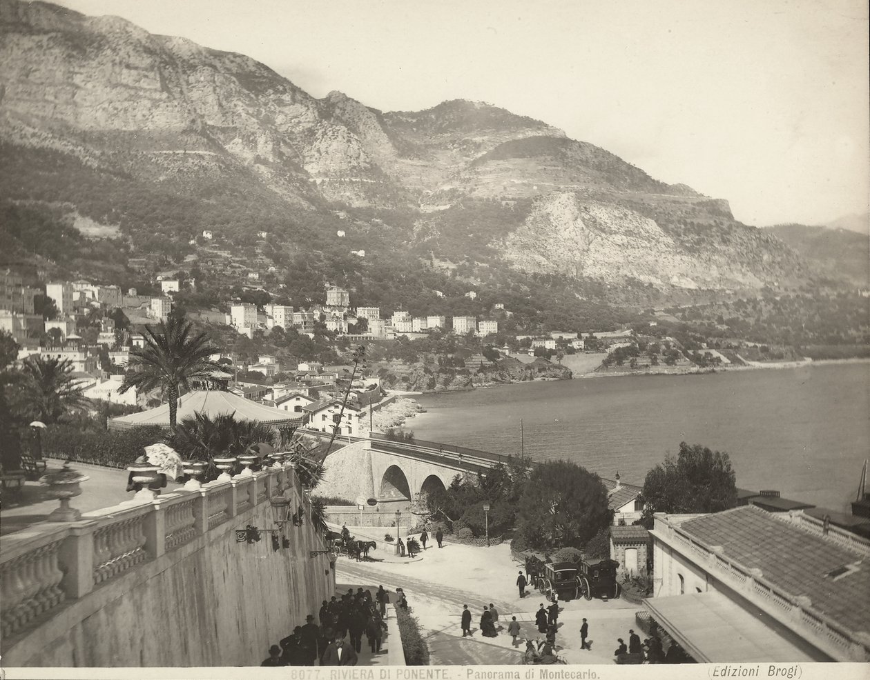 Panoramatický výhled na Montecarlo v Monaku. Scéna ukazuje různé kolemjdoucí; vlevo vidíme detailní záběr na mramorovou balustrádu od Giacomo Brogi