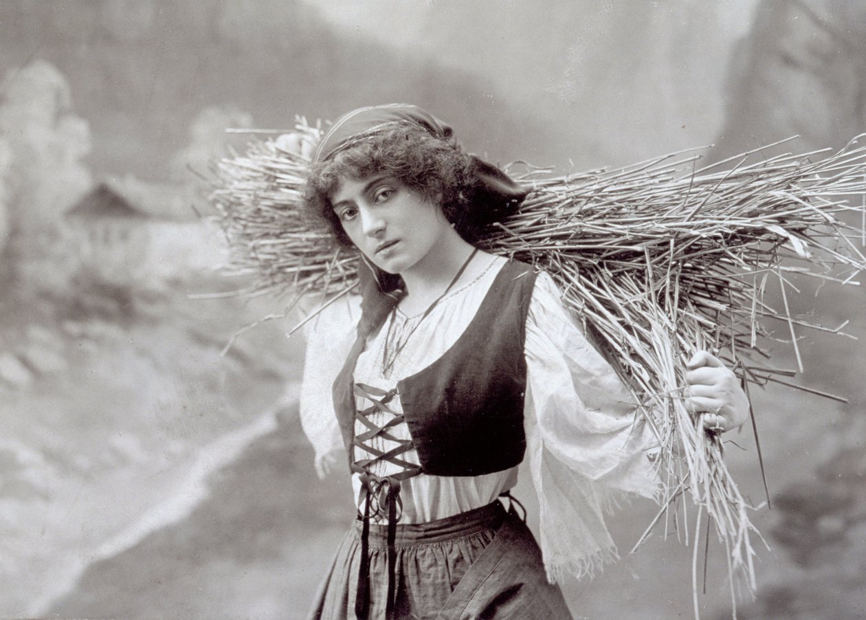 Mladá žena v tradičním oděvu nesoucí balík slámy (černobílá fotografie) od Giacomo Brogi