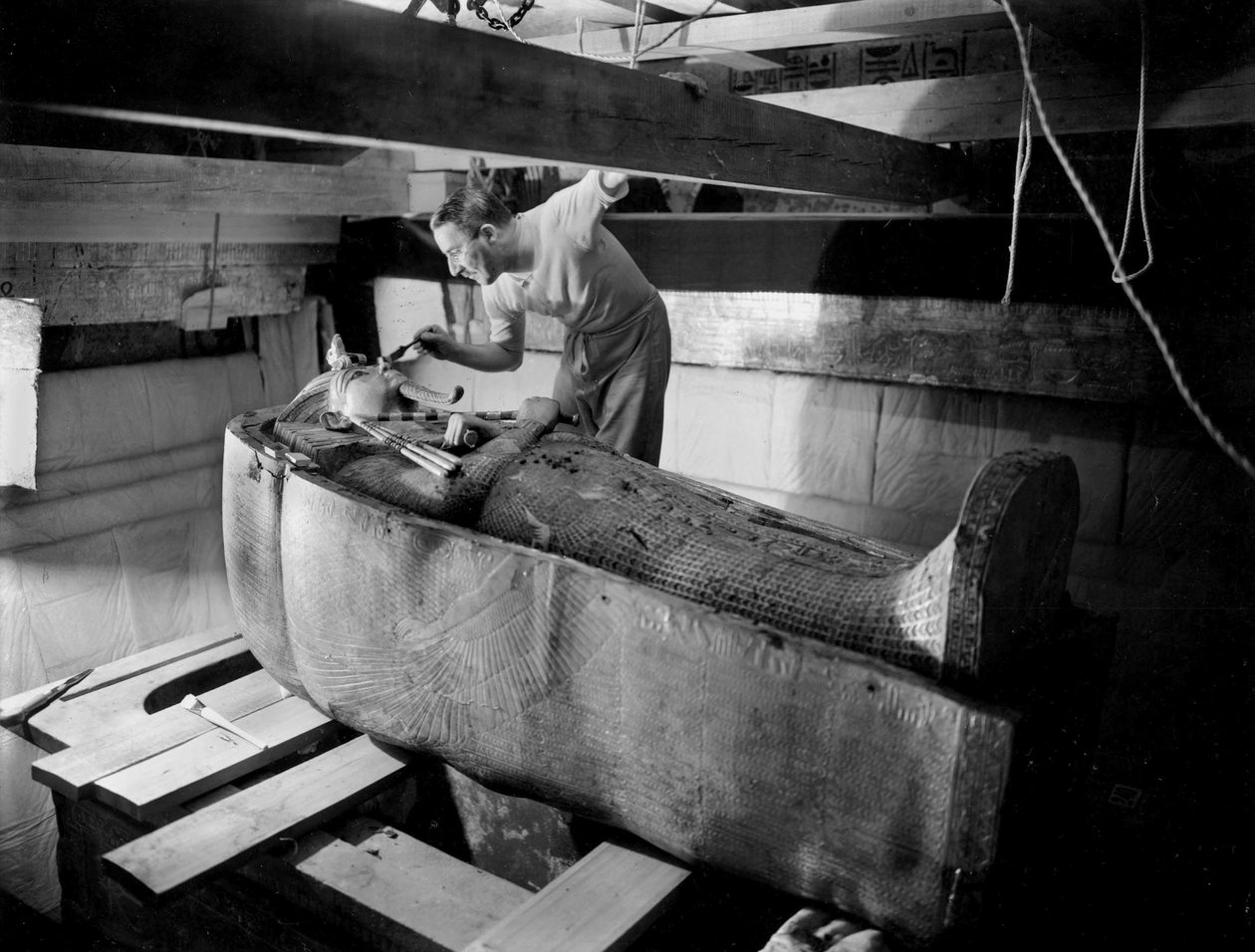 Objev hrobky faraona Tutanchamona v Údolí králů (Egypt): v pohřební komoře Howard Carter pracuje na víku druhé rakve, říjen 1925, foto Harry Burton (p1568) od Harry Burton