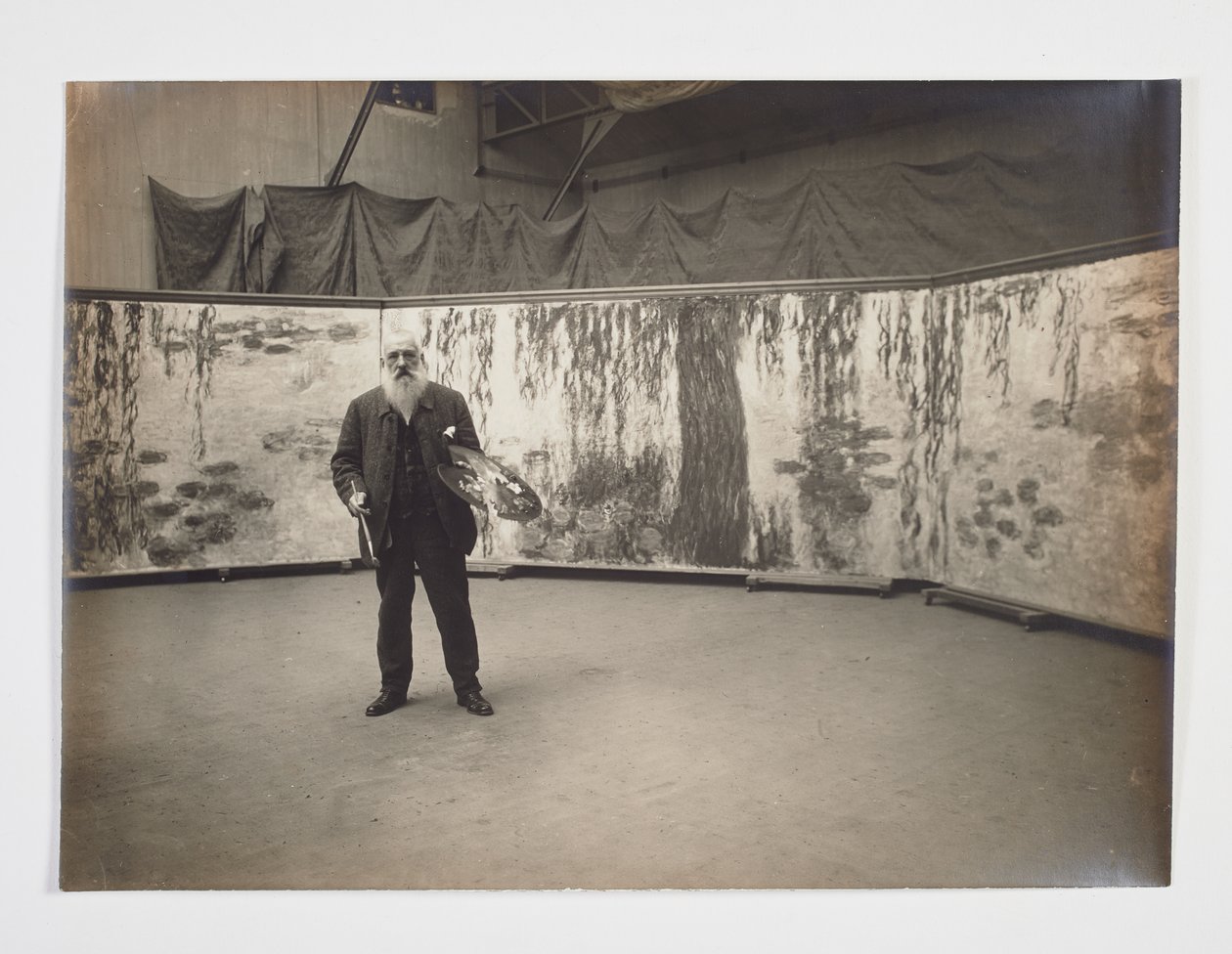 Claude Monet se svou paletou před dílem „Les nymphéas“ od Henri (attr. to) Manuel