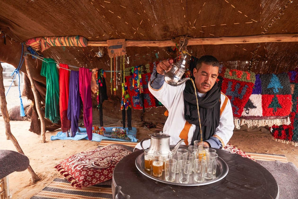 Místní obyvatel podává mátový čaj v poušti Erg Chebbi nedaleko Merzougy, Maroko, 2019 (foto) od Ira Block