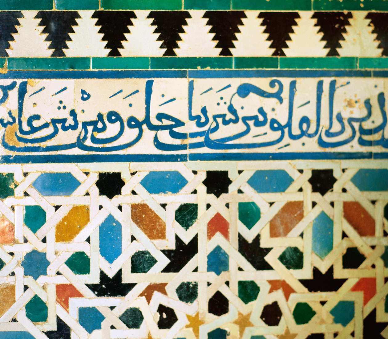ringe s nápisem v modré dlaždici na bílém pozadí reprodukující věty koránu od Islamic School
