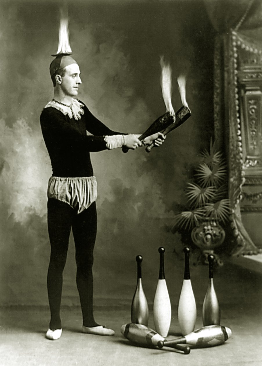 J.T. Doyle, cirkusový a karnevalový žonglér s hořícími kolíky a mísou, asi 1902 (čb fotografie) od J.E. Pasonault
