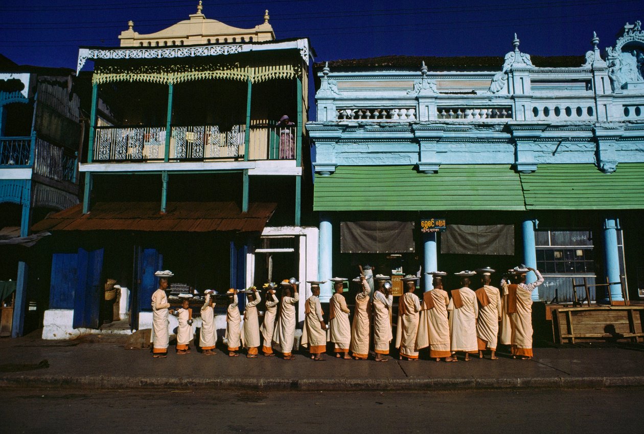 Buddhistické mnišky různého věku se promenádují po chodníku a žádají o almužnu. Maymyo, Barma. od James L Stanfield
