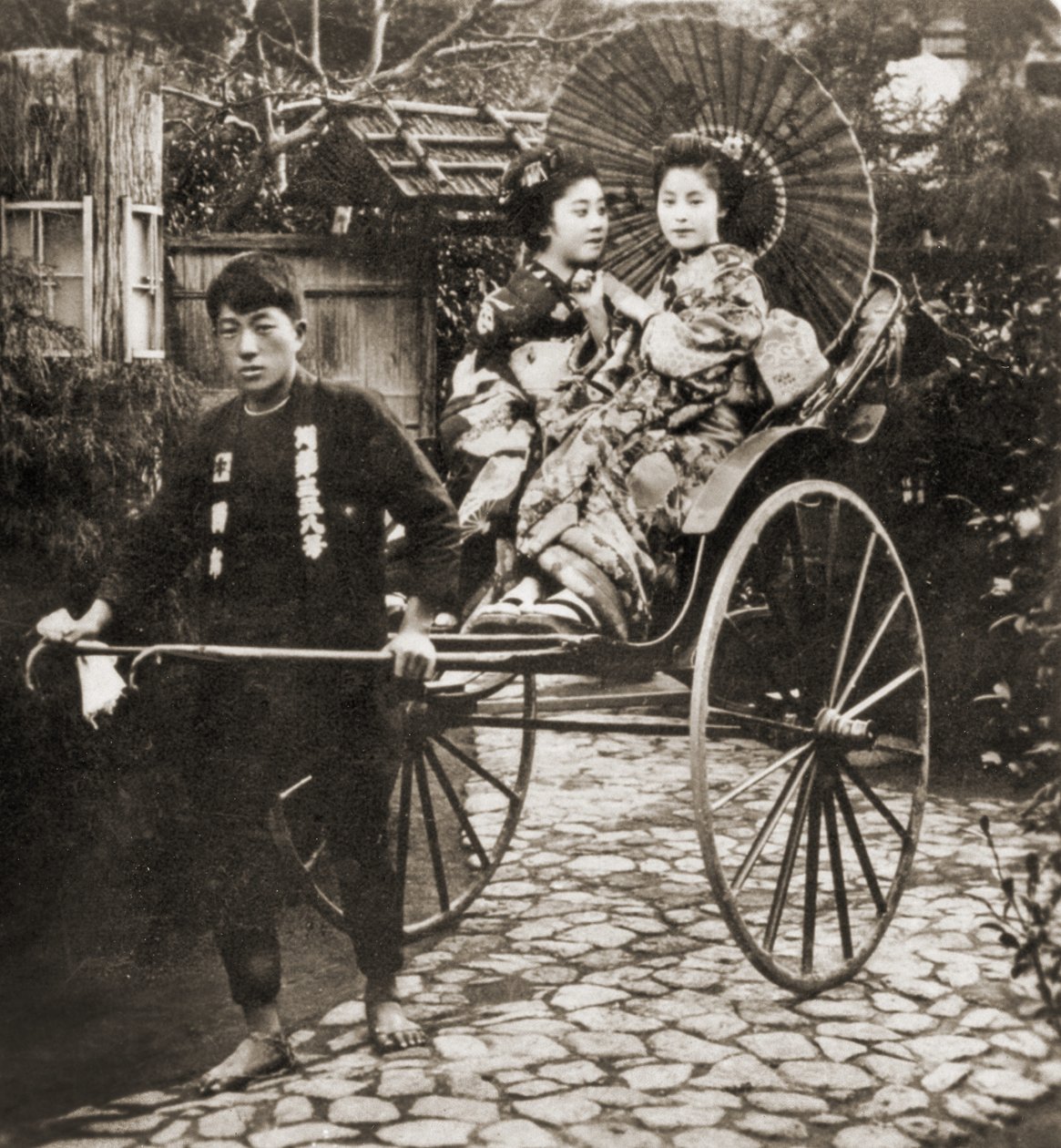 Běžec táhnoucí dvě gejše na rikši v Japonsku, kolem roku 1900 (foto alba) od Japanese Photographer