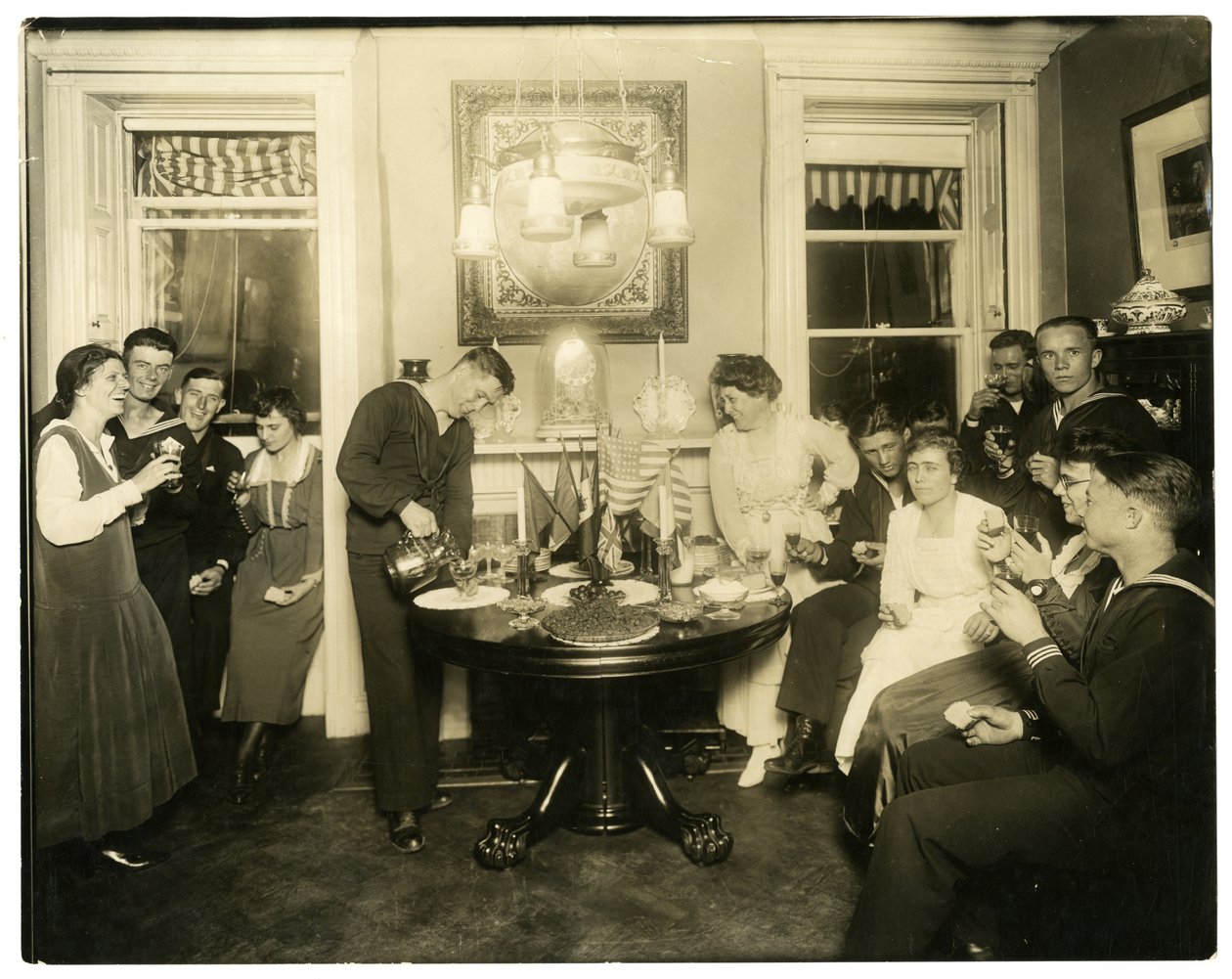Alice Foote MacDougalová baví skupinu námořníků ve svém malém bytě ve staré válce, Greenwich Village, New York, USA, cca 1917-18 (želatinová stříbrná fotografie) od Jessie Tarbox Beals