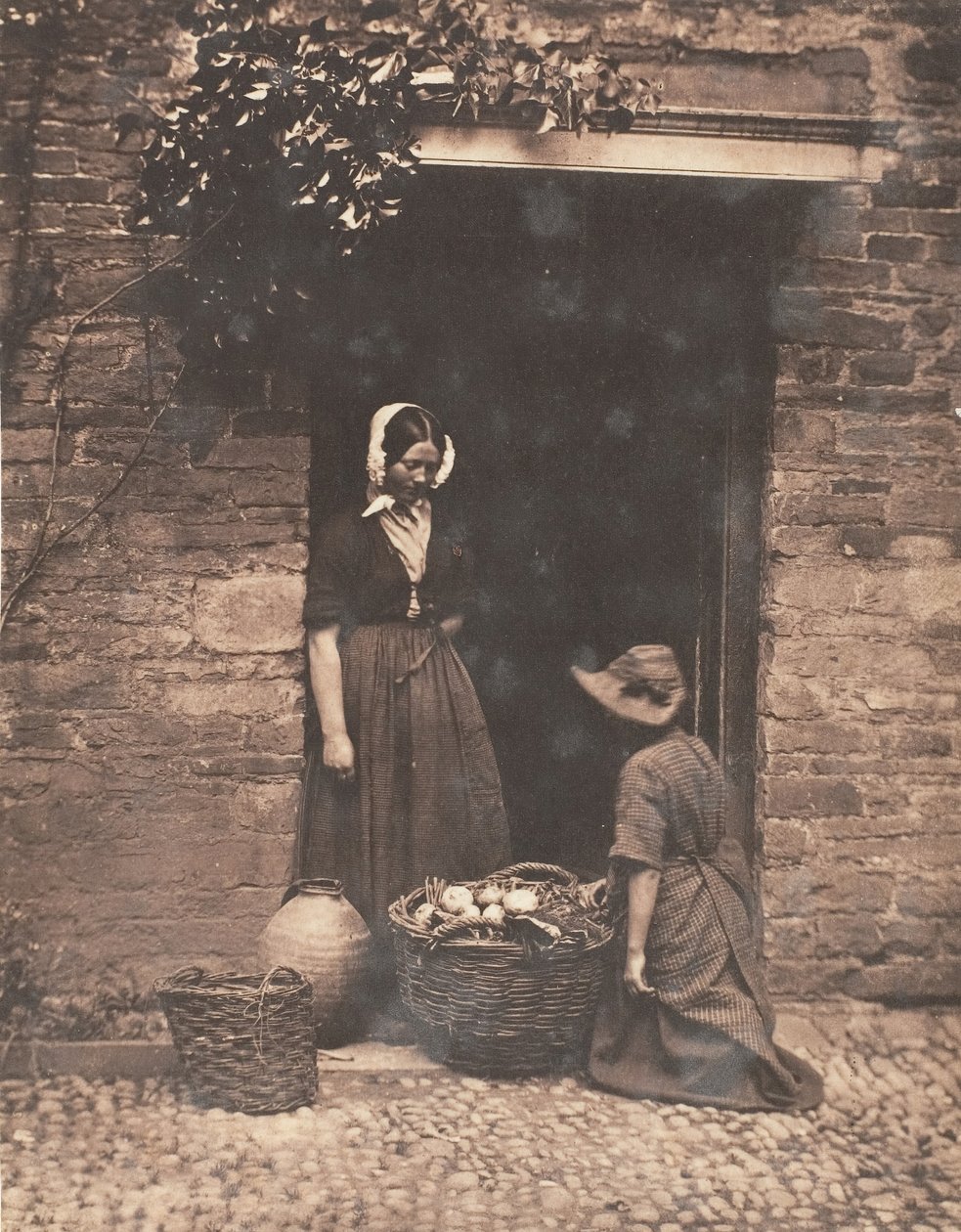 [Dvě ženy, jedna klečící a jedna stojící, hledící do koše plného zeleniny], 1853-56. od John Dillwyn Llewelyn