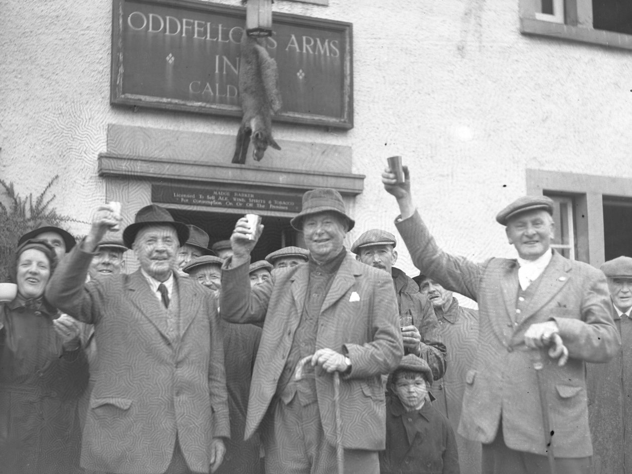 Skupina mužů, žen a dětí zvedá sklenice na oslavu před hostincem Oddfellows Inn. od Joseph Hardman