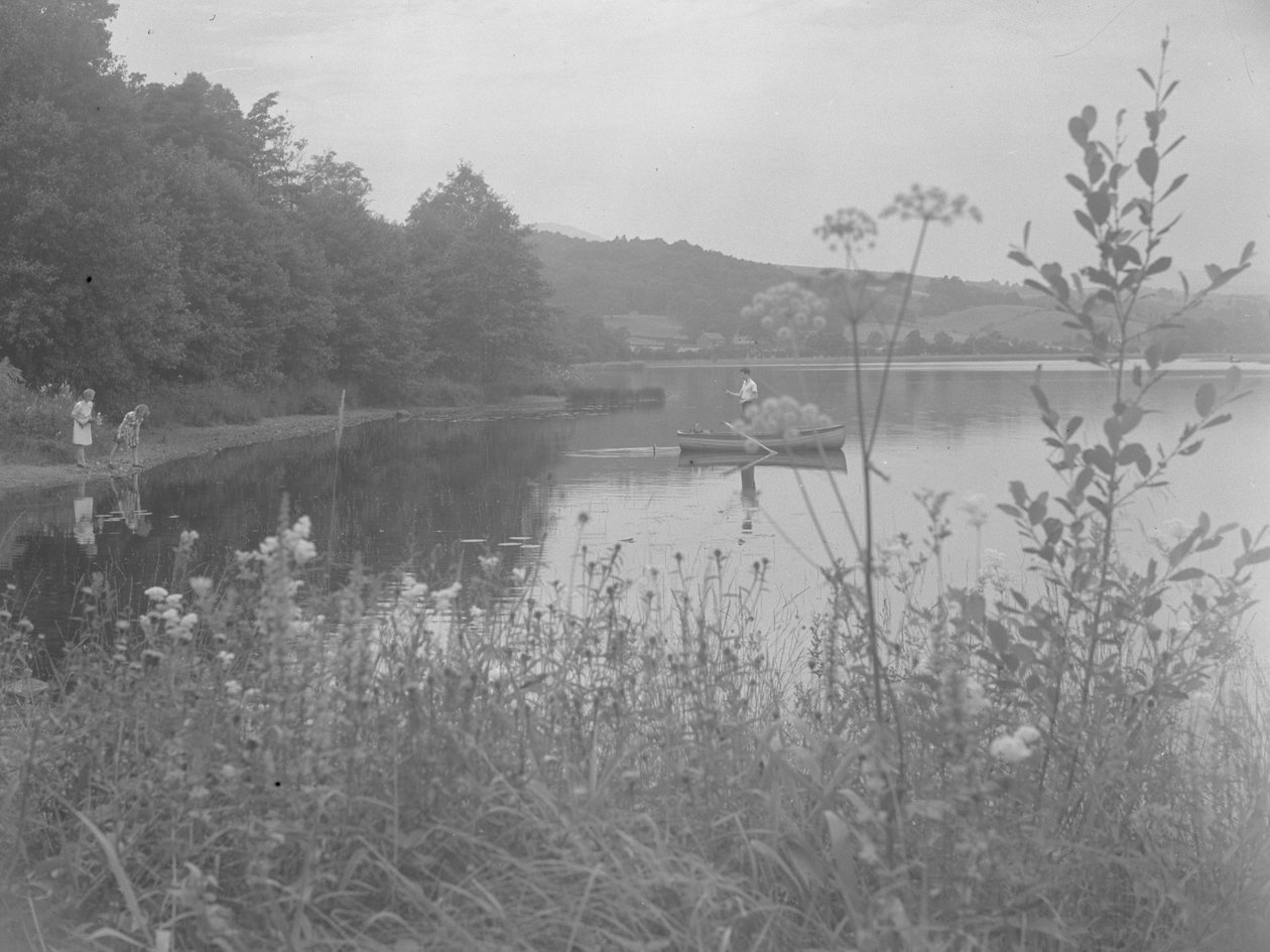 Muž rybařící na člunu na vodě Estwaite Water a dvě dívky na břehu vody od Joseph Hardman