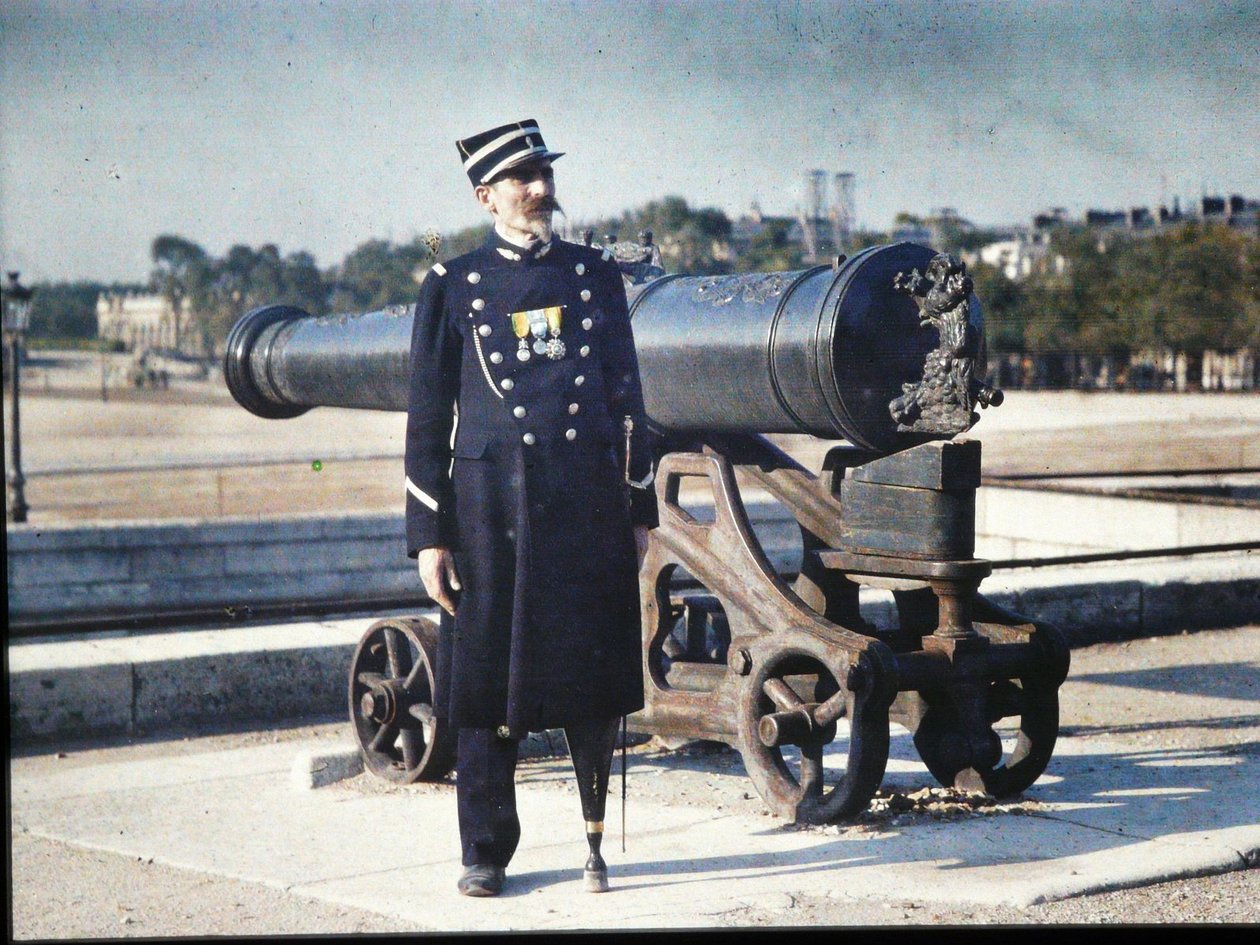 Voják v uniformě se třemi medailemi stojí vedle děla v Paříži, 1918 (autochrom) od Jules Gervais Courtellemont