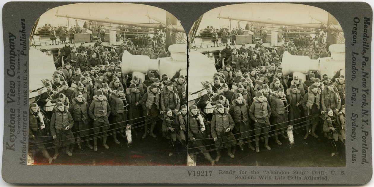 Horizontální, sépiová stereokarta zobrazující uniformované americké vojáky v záchranných vestách stojících a sedících na palubě lodi. Keystone Stereograph number V19217. Název zní od Keystone View Company
