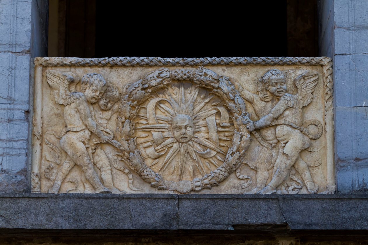 Balustrádová deska s paprskem slunce v girlandě, basreliéf na fasádě kostela San Sebastiano od Leon Battista Alberti