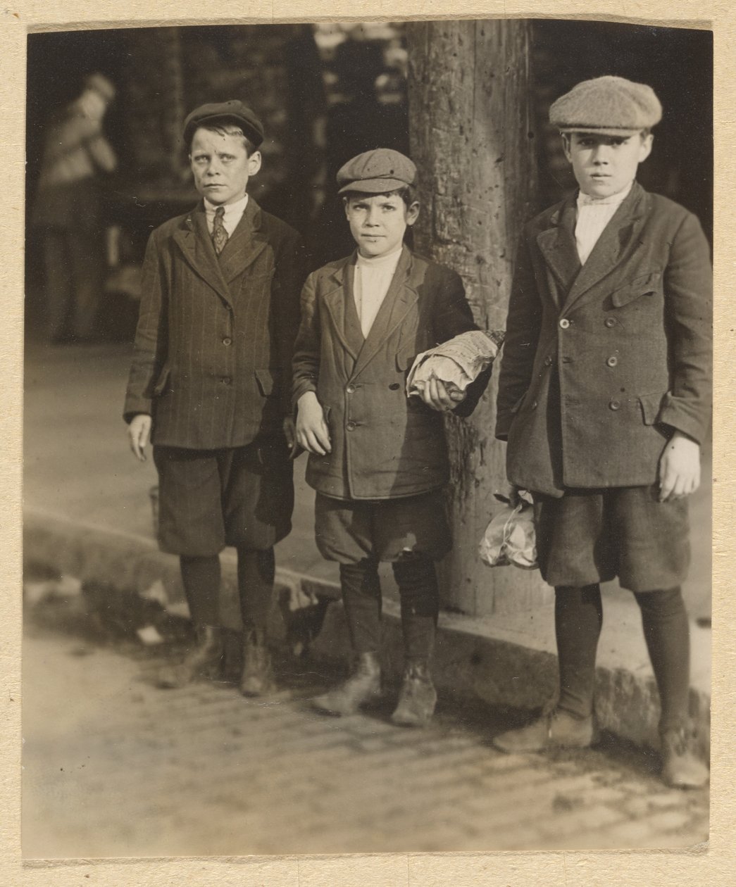 [Tři chlapci na městské ulici v kalhotách a čepicích] od Lewis W. Hine