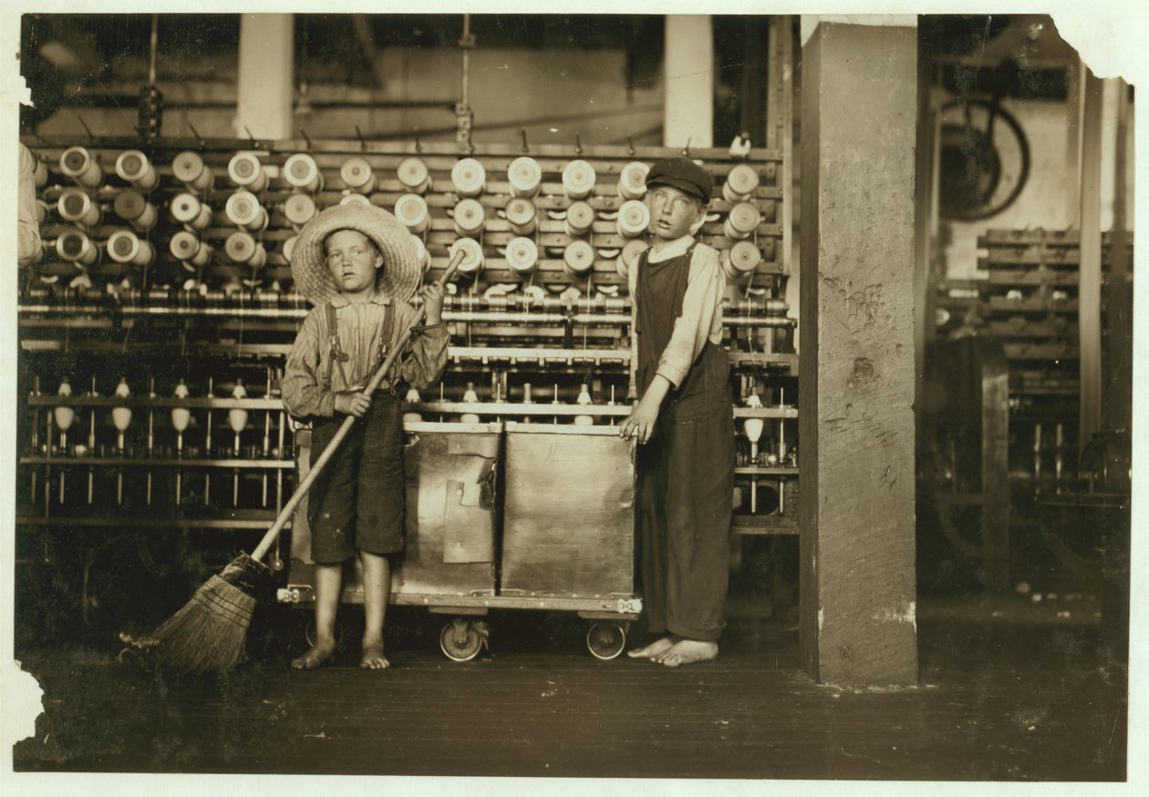 12letý doffer Ronald Webb a 7letý Frank Robinson, syn šéfa kartonáže, který zametá a sundává (vyčistí celé cívky) v Roanoke Cotton Mills, Virginia, 1911 od Lewis Wickes Hine