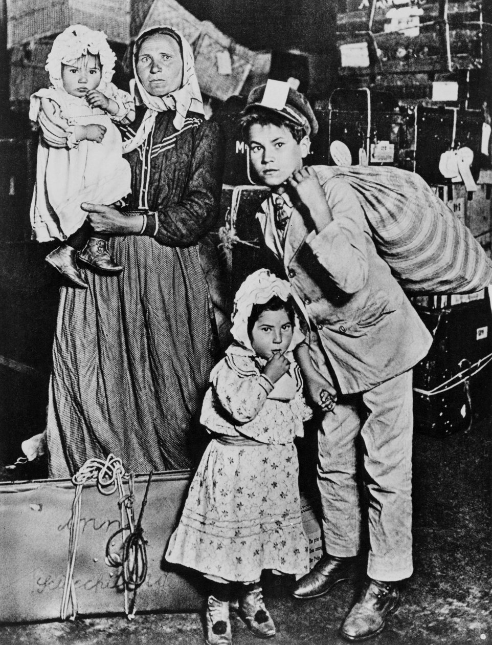 Imigranti přijíždějící na Ellis Island na počátku 20. století (černobílá fotografie) od Lewis Wickes Hine