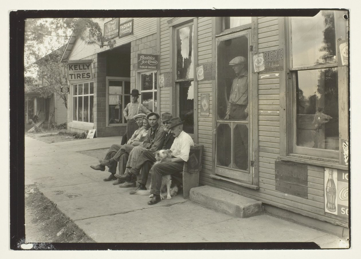 Muži se psem sedící na lavičce před obchodem General Store od Lewis Wickes Hine