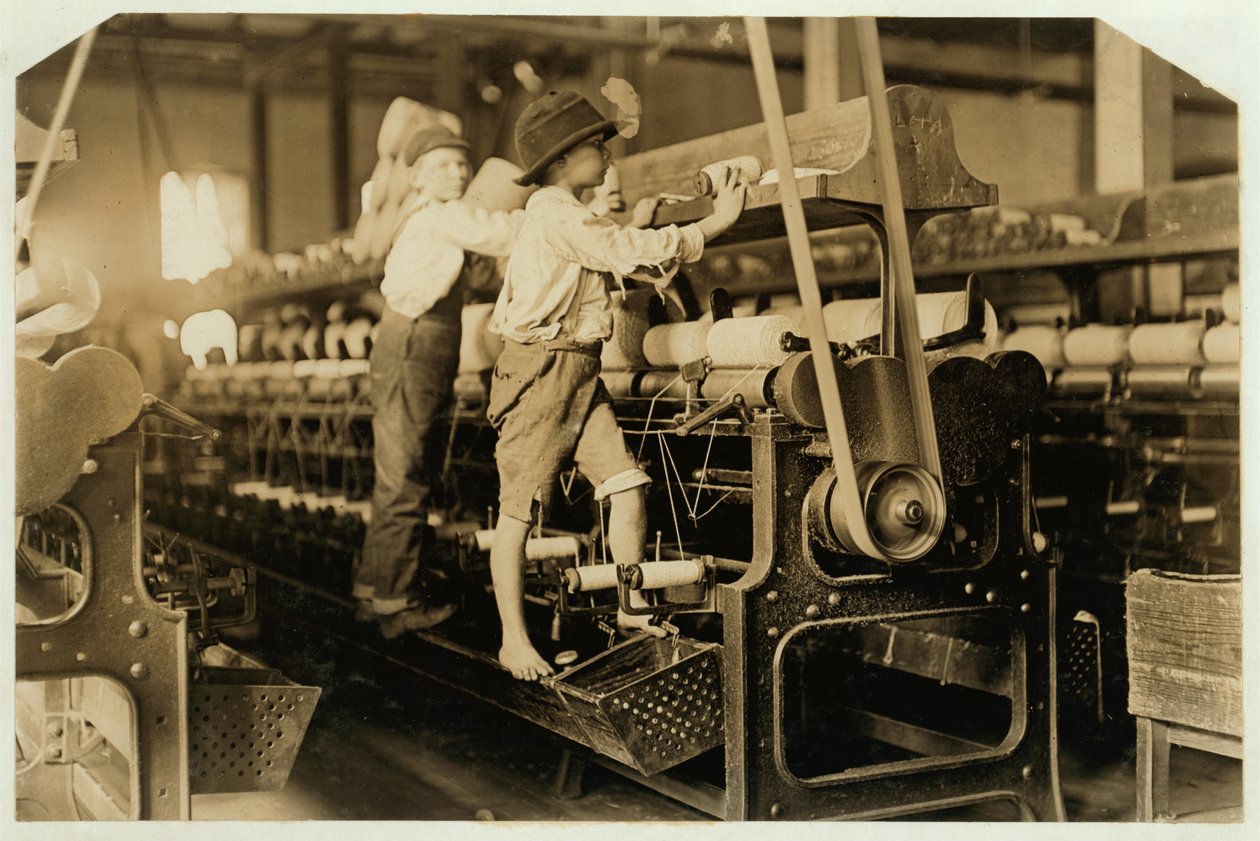 Malí chlapci lezoucí na kolovrat, aby opravili přetržené nitě a nahradili prázdné cívky v Bibb Mill, Macon, Georgia, 1909 od Lewis Wickes Hine