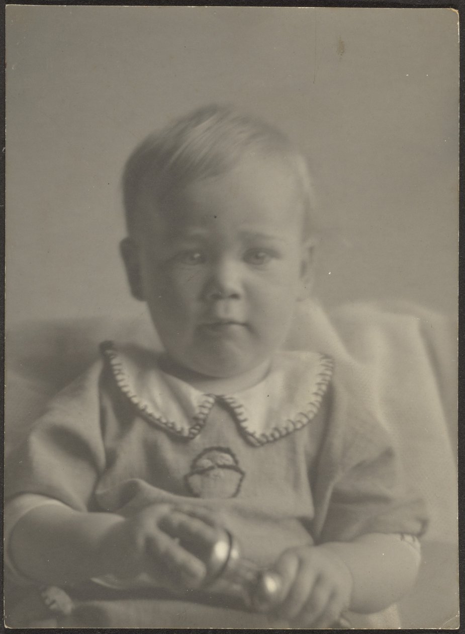 Dítě držící stříbrné chrastítko od Louis Fleckenstein
