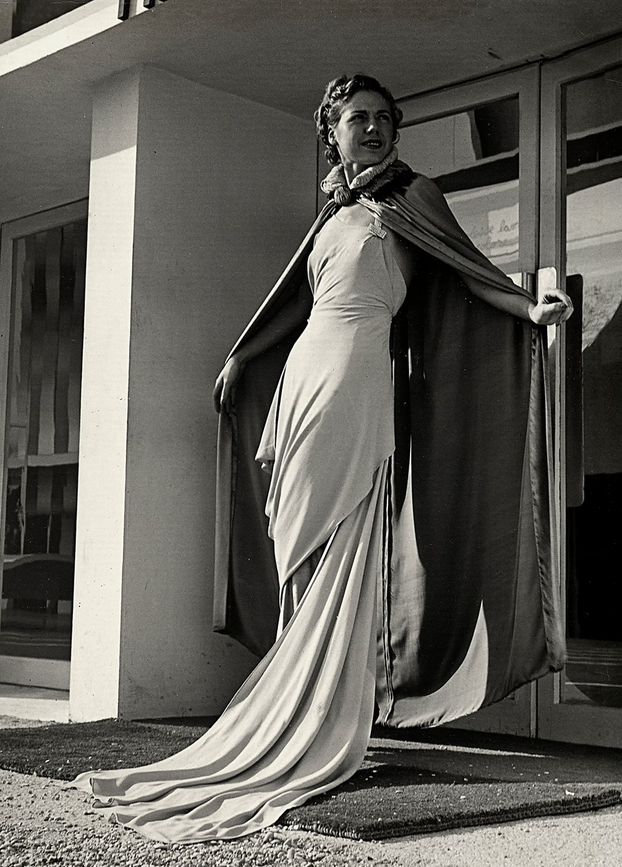 Model ve večerních šatech vytvořený couture house "Graldi". Článek je doplněn pláštěm z lehké tkaniny. (černobílá fotografie) od Luis Bogino