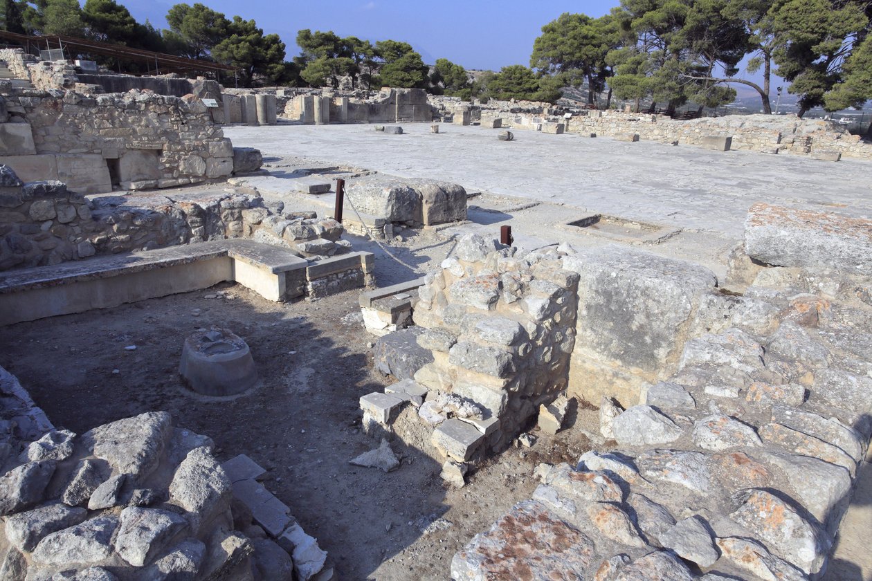 Minojské archeologické naleziště Phaistos. Centrální nádvoří a „“Lavicová svatyně””: malá a obdélníková místnost s nízkými lavicemi pobíhajícími kolem zdí na podporu kultovních předmětů a sošky božstva. Na některých z nich byly nalezeny ženské figurky, rit od Minoan