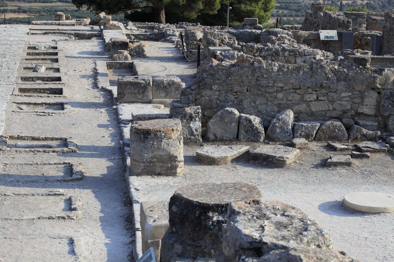 Minojské archeologické naleziště Phaistos. Celkový pohled na svatyně západního křídla podél centrálního dvora ze severního křídla. Existovaly dva typy svatyní: „Svatyně na lavici“ a „Lutrální pánev“. „Svatyně lavice“ byla malá a obdélníková místnost s nízk od Minoan
