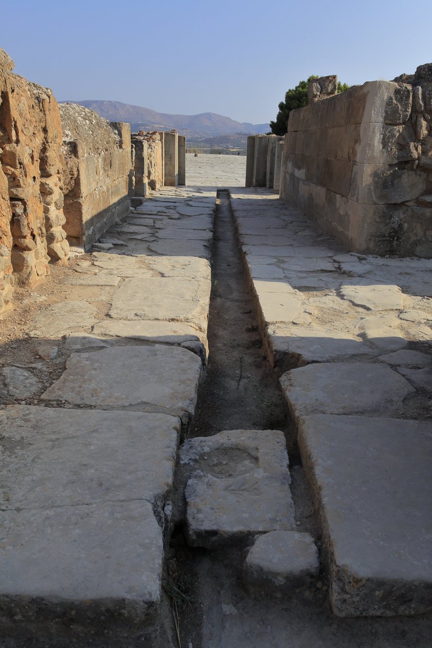 Minojské archeologické naleziště Phaistos. Široká chodba s odvodňovacím kanálem za bránou severního křídla ústící z centrálního dvora a vedoucí do vnitřního dvora vedle Royal Apartments. Phaistos, Kréta. od Minoan
