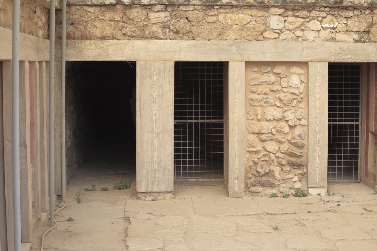 Minoen archeologické naleziště Knossos. Západní křídlo vedle „“tripartitní svatyně““. Místnost se dvěma velkými obdélníkovými sklady zapuštěnými do podlahy. Byly plné hliněných váz a cenných obcí, mezi nimiž byly slavné sošky představující „Hada od Minoan