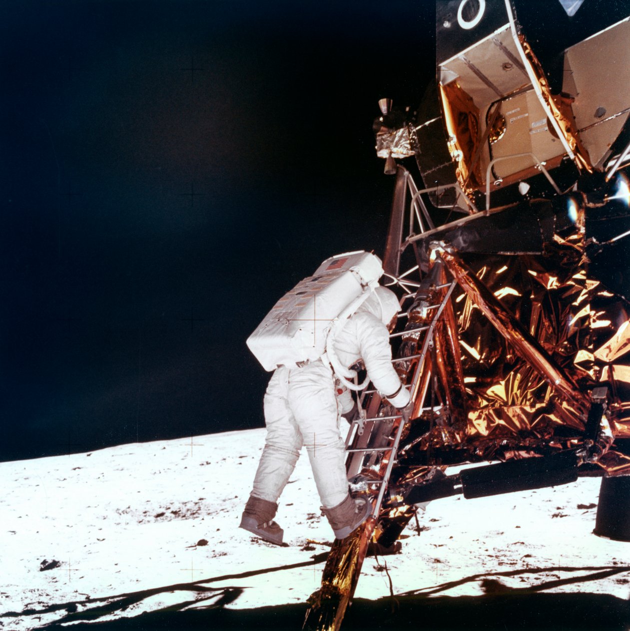 Edwin Buzz Aldrin sestupuje po schodech žebříku lunárního modulu, aby se prošel po Měsíci, 1969. od NASA Images