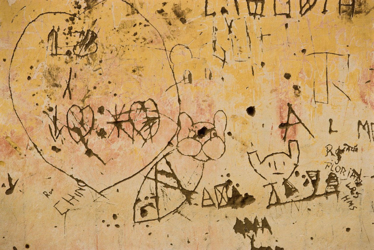 Grafitti vyryté do staré venkovní omítky. od Nathan Benn