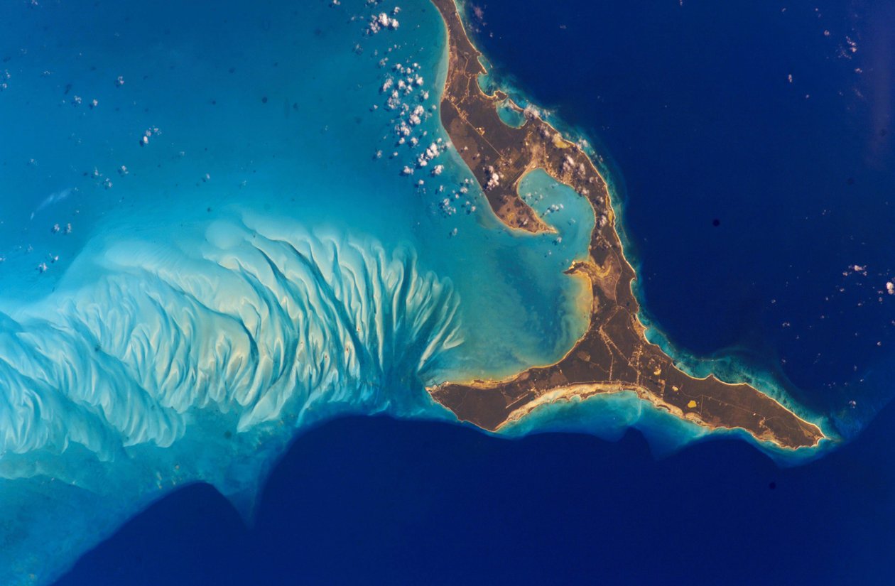Ostrov Eleuthera, Bahamy, 2002. Podvodní útvary na západ od ostrova jsou vyrobeny z písku uhličitanu vápenatého erodovaného z korálových útesů a usazeného v dunách oceánskými proudy. Poděkujte NASA. Věda E od National Aeronautics and Space Administration National Aeronautics and Space Administration