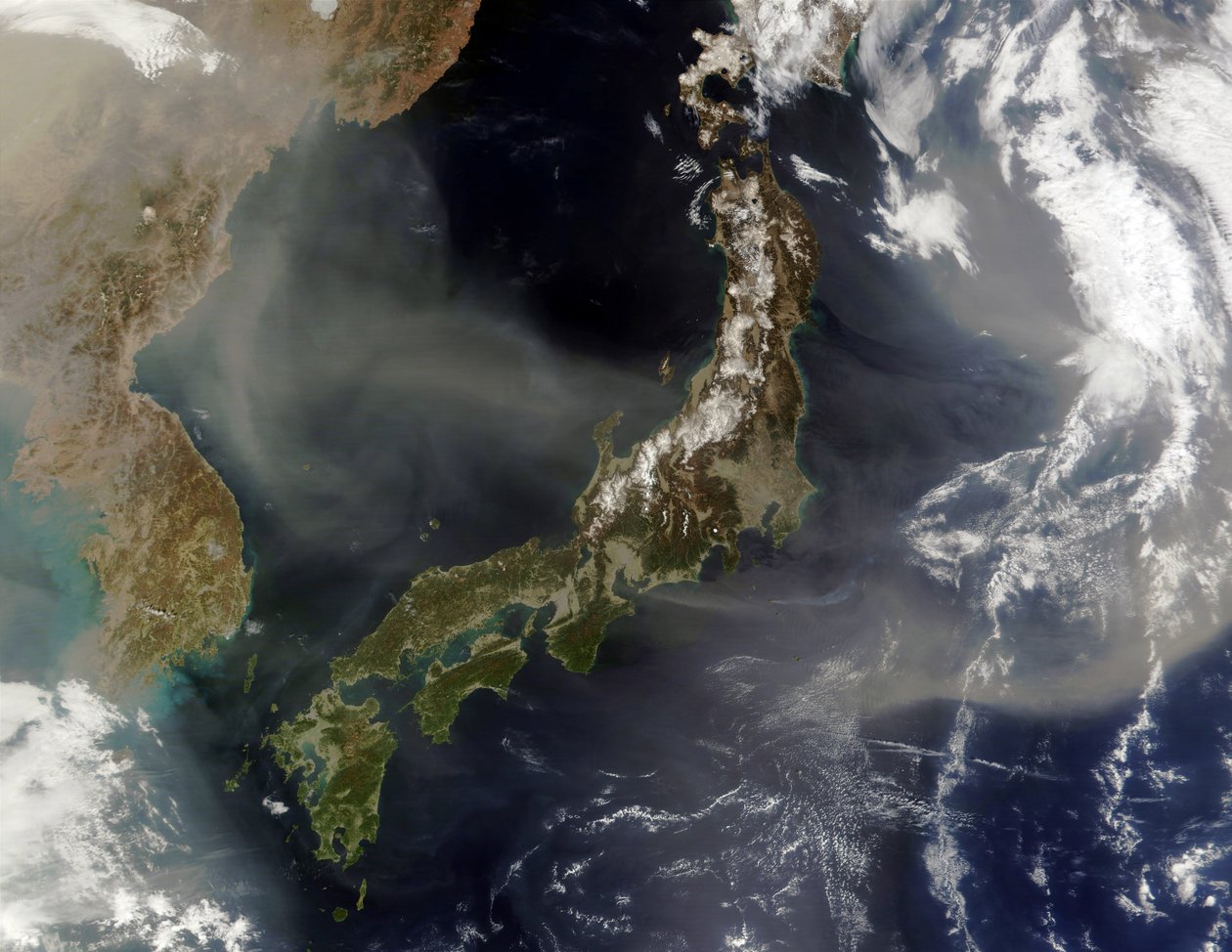 Satelitní pohled na Japonsko se zasněženými horami, jarní ozelenění země na nižších úrovních. Prach z pevninské Číny vanoucí přes Japonské moře a ven do Tichého oceánu. Kredit: NASA. Věda od National Aeronautics and Space Administration National Aeronautics and Space Administration