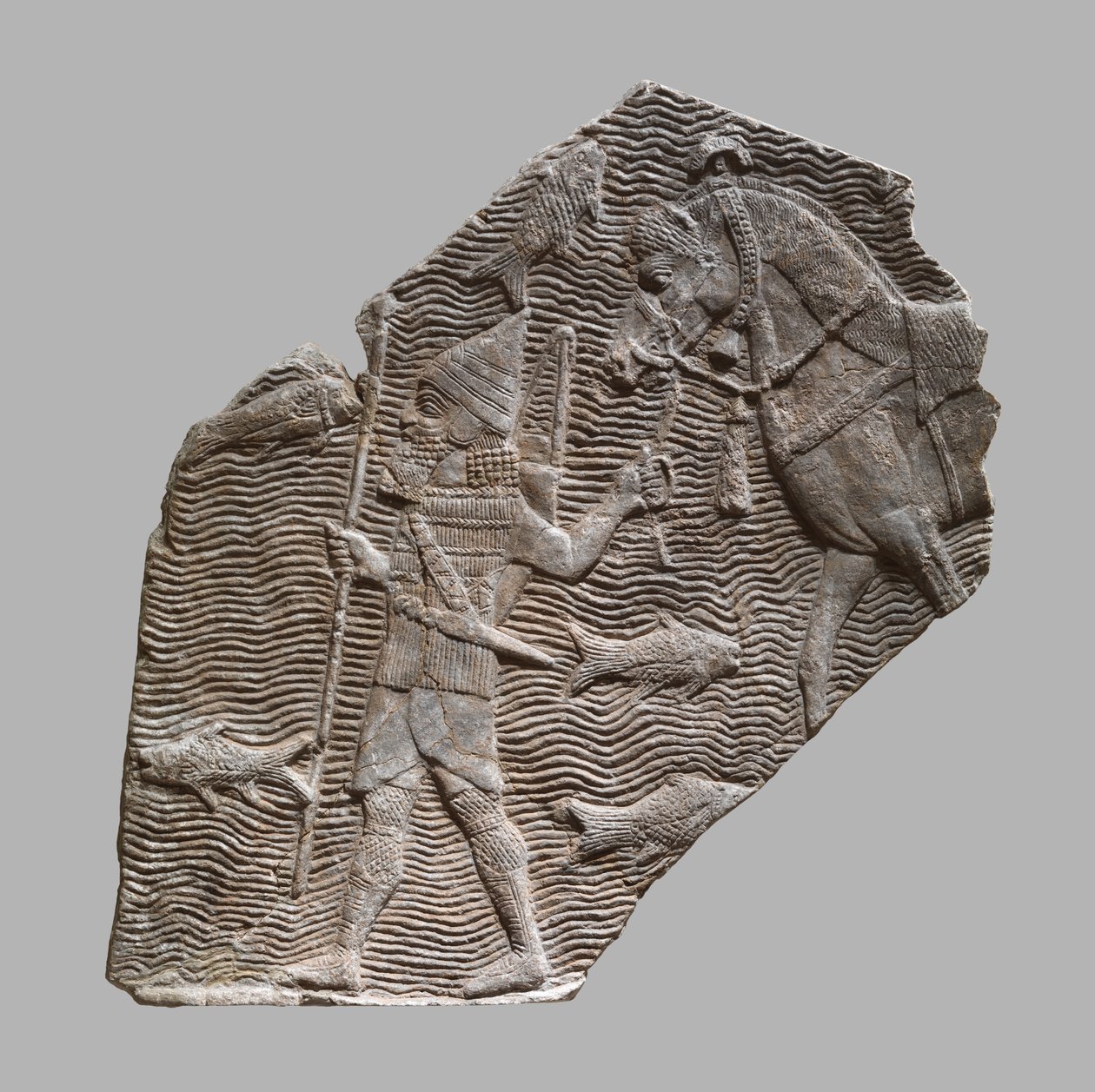 Úlomek reliéfu: jezdec vedoucí svého koně u potoka, cca 704–681 př. Kr. (sádra alabastr) od Neo Assyrian